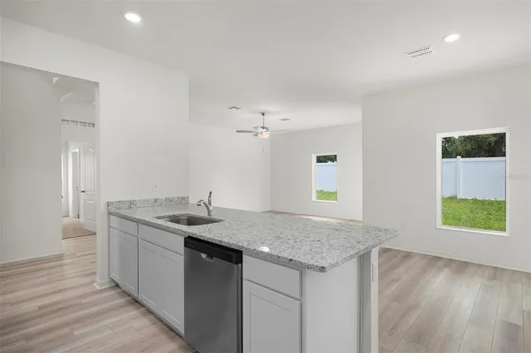 a kitchen with a granite countertop sink and a window