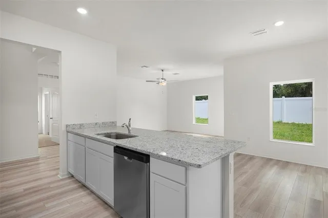 a kitchen with a granite countertop sink and a window