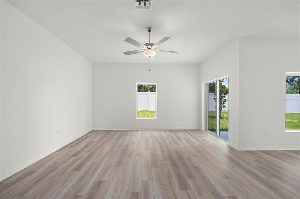 13288 Tula Loop Astatula, FL 34705 - Photo 7 of 23 wooden floor in an empty room with a window