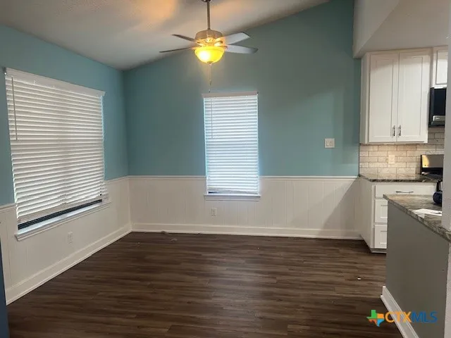 a view of kitchen and center island in wooden floor