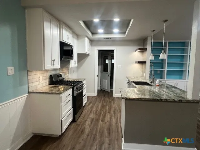 a kitchen with stainless steel appliances granite countertop a stove and a sink
