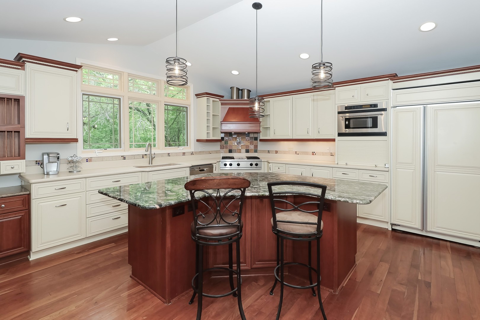7704 Newbold Road Cary, IL 60013 - Photo 15 of 56 a kitchen with stainless steel appliances granite countertop a stove a sink dishwasher a refrigerator and a dining table with wooden floor