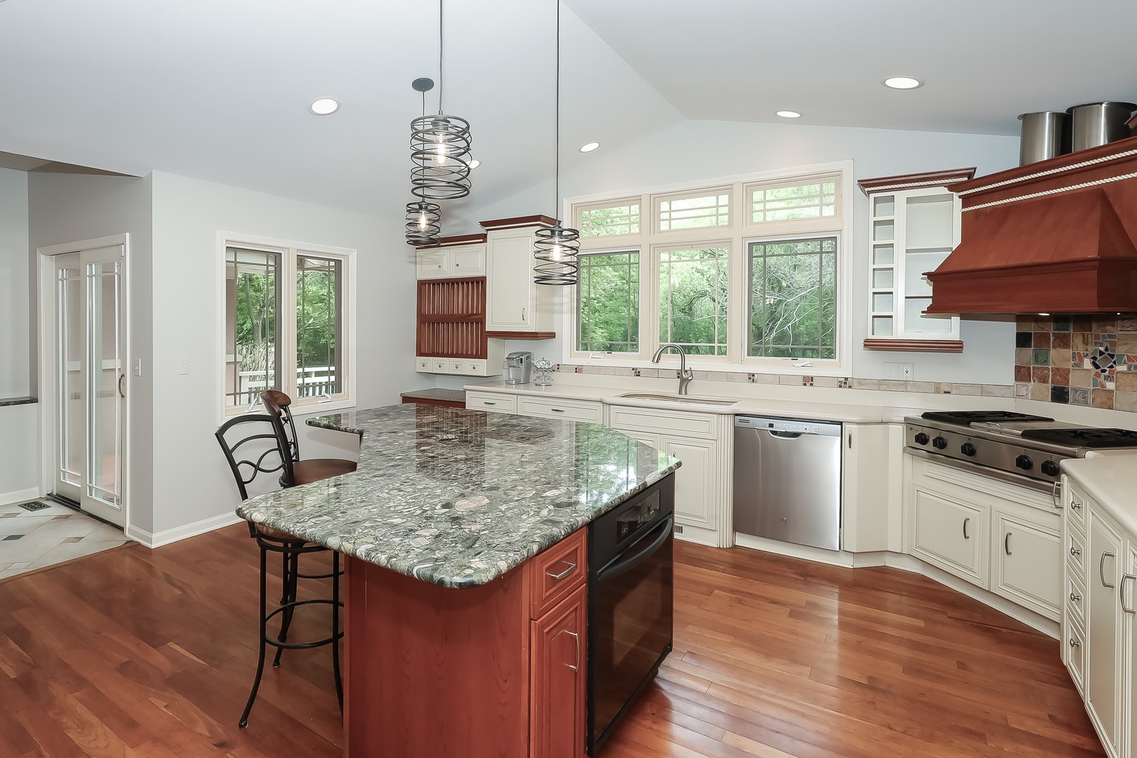 7704 Newbold Road Cary, IL 60013 - Photo 16 of 56 a kitchen with stainless steel appliances granite countertop a sink a stove a dining table and chairs