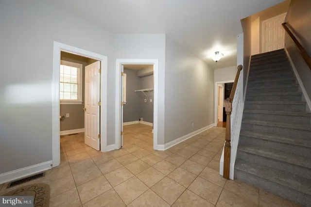 a bathroom with a granite countertop toilet a sink a mirror and a window
