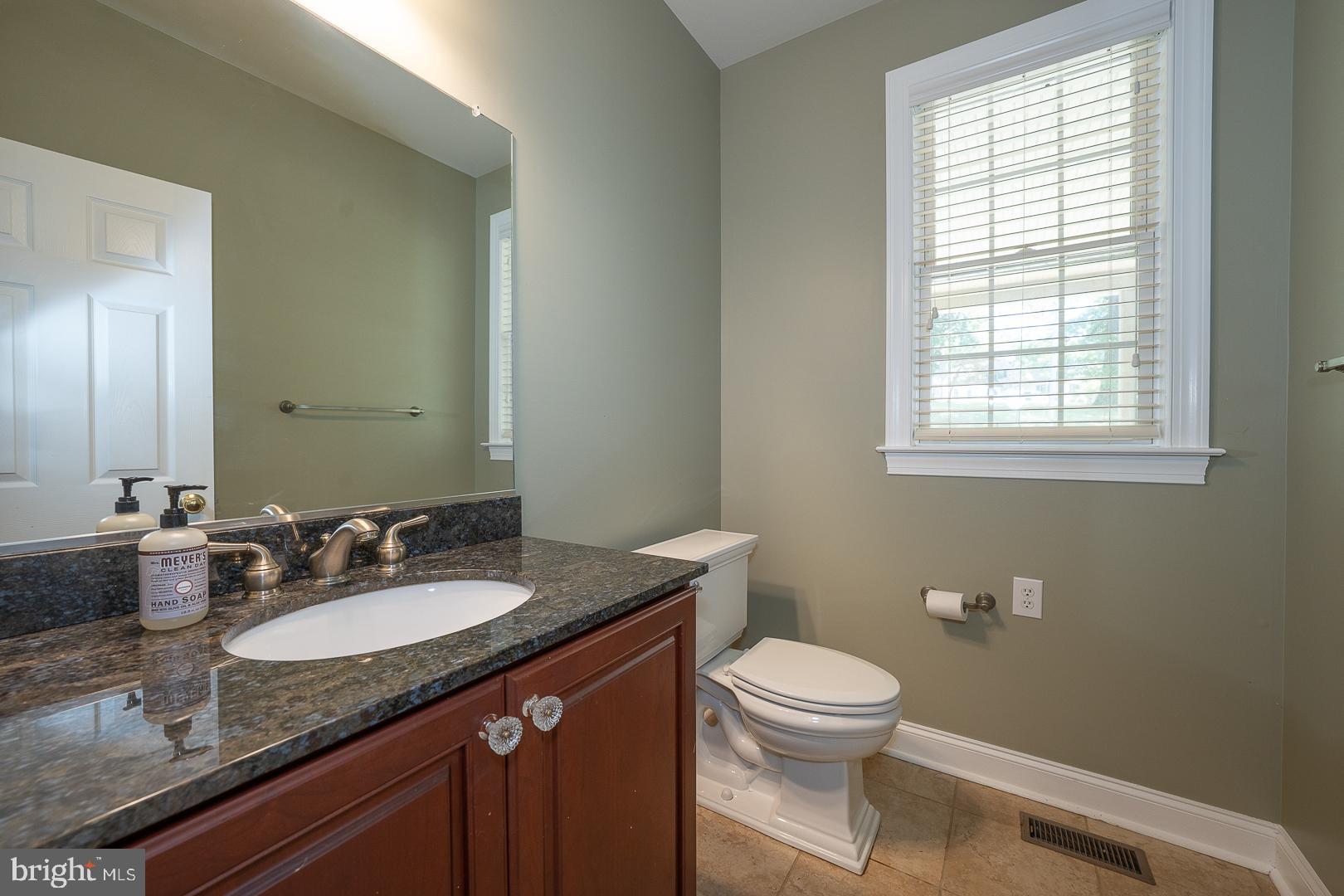 2140 Howell Road Malvern, PA 19355 - Photo 25 of 47 a bathroom with a granite countertop toilet a sink a mirror and a window