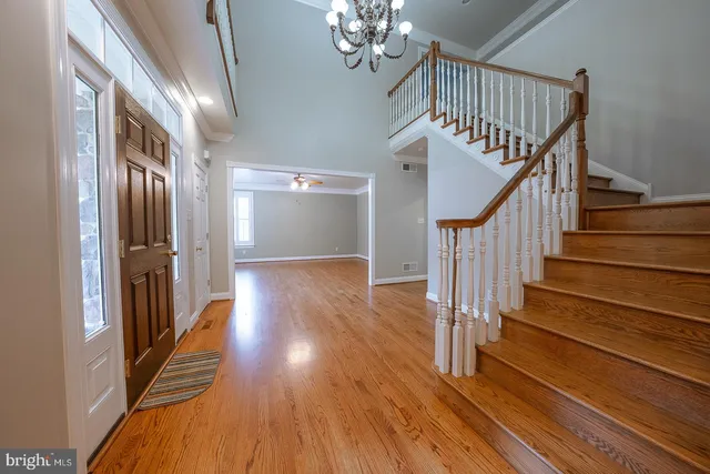 a view of staircase with wooden floor and a chandelier