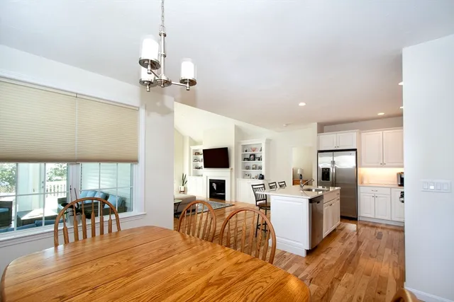 a living room with stainless steel appliances kitchen island granite countertop furniture and a wooden floor