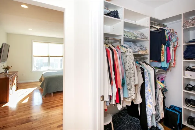 a view of walk in closet with clothes and shoes
