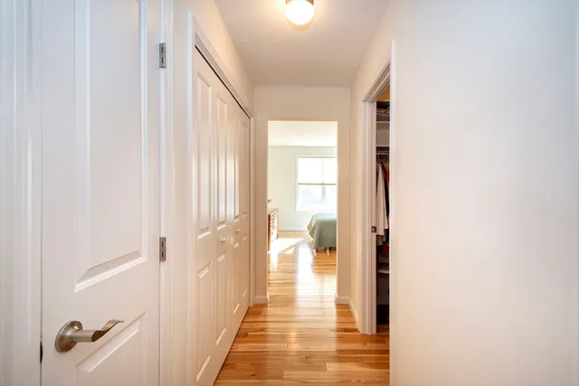 a view of a hallway with wooden floor and closet