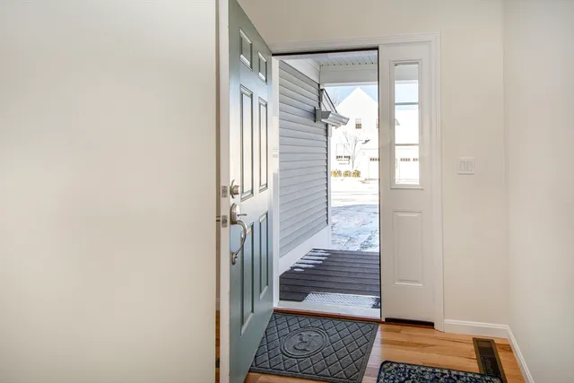 a view of entryway with wooden floor and next to a window