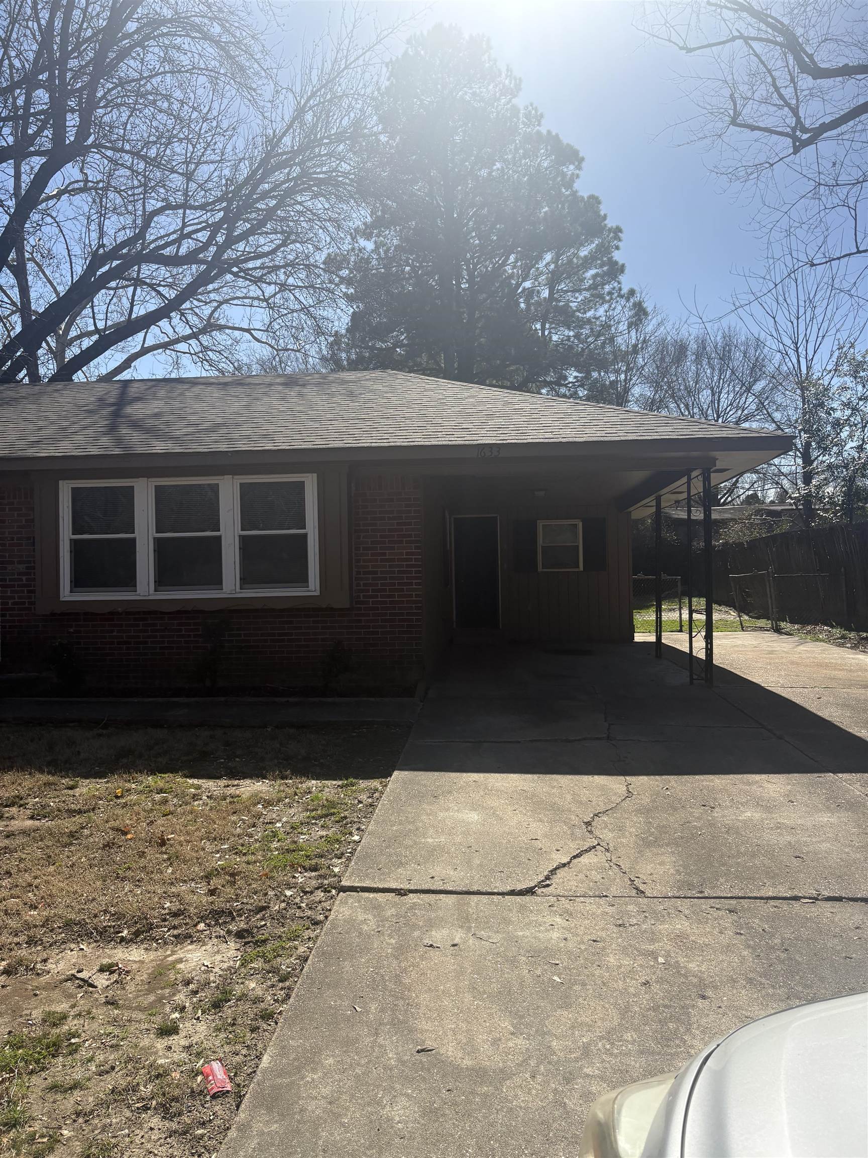 1633 Puryear Road Memphis, TN 38116 - Photo 5 of 5 View of front of house featuring concrete driveway, a carport, brick siding, and a shingled roof