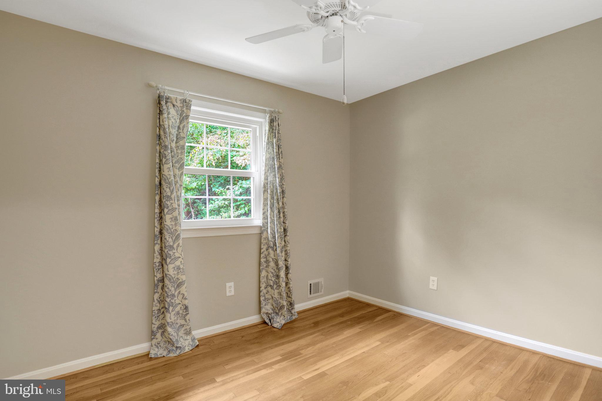 8706 Fox Ridge Road Springfield, VA 22152 - Photo 36 of 76 an empty room with wooden floor fan and windows