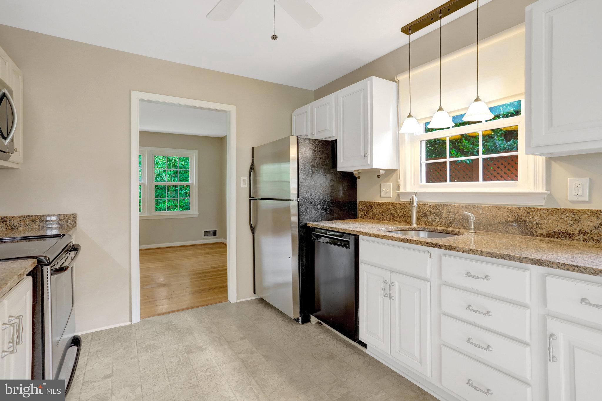 8706 Fox Ridge Road Springfield, VA 22152 - Photo 10 of 76 a kitchen with granite countertop a refrigerator and a sink