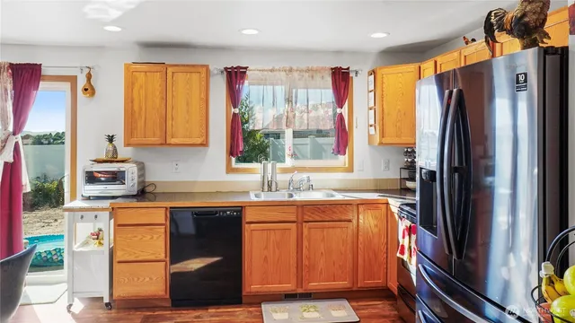 a kitchen with stainless steel appliances granite countertop a refrigerator and a sink