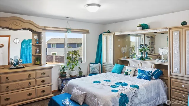 a bedroom with a bed and large windows