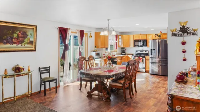 a dining room with furniture a chandelier and wooden floor