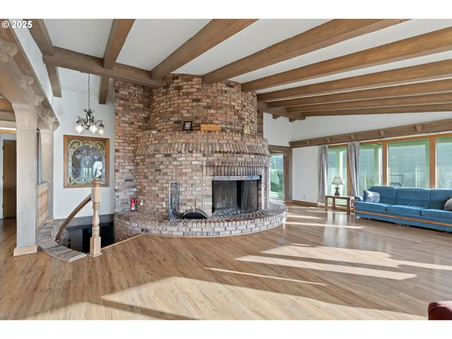 a view of a livingroom with wooden floor and a fireplace