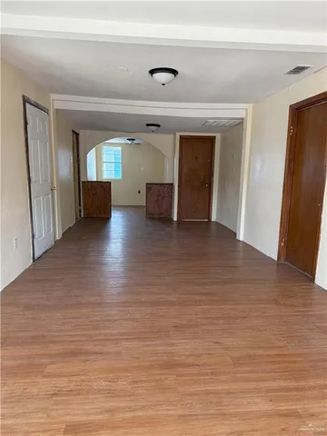 a view of empty room with wooden floor and fireplace