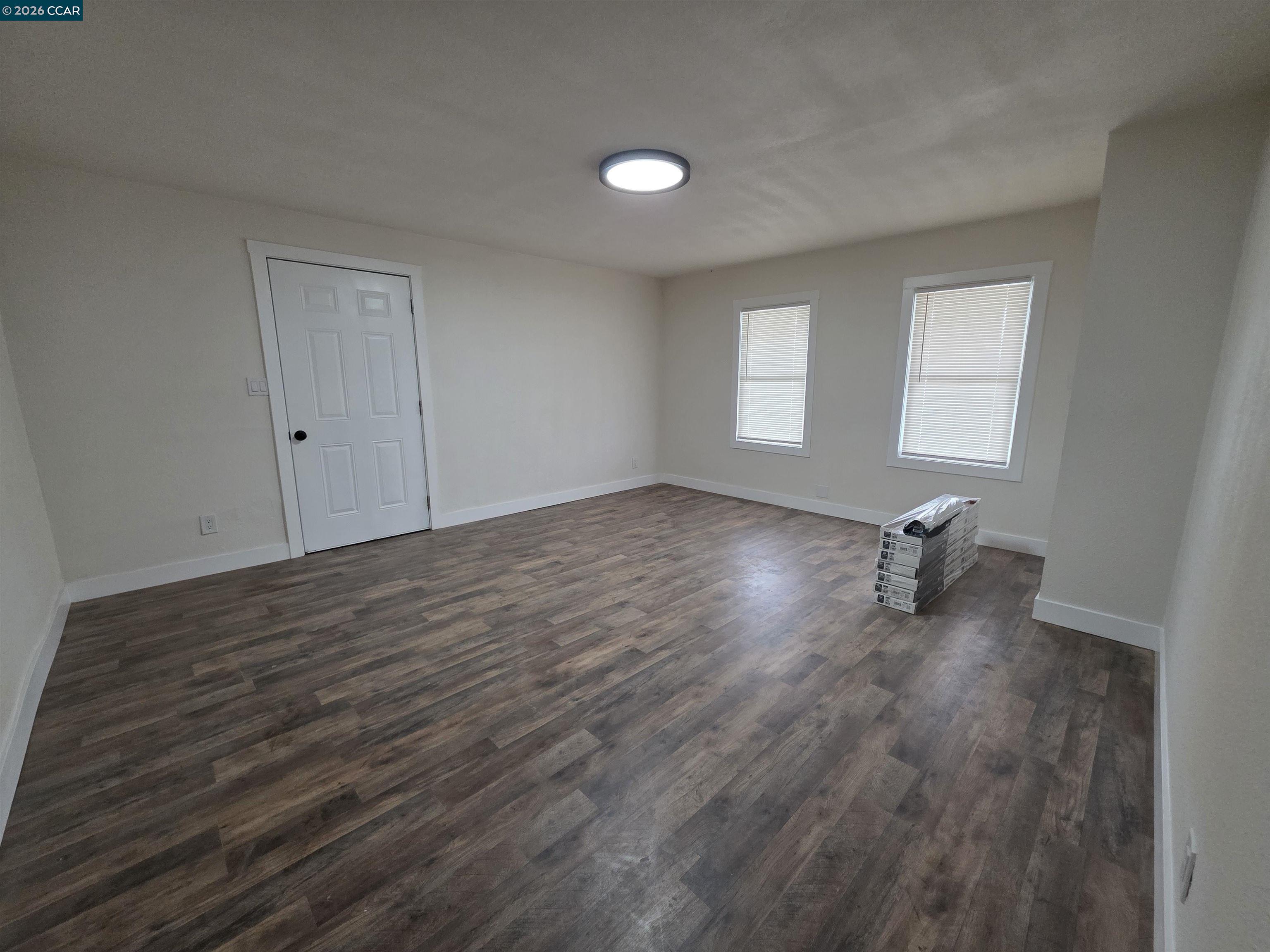 139 Ambrose Avenue, Unit A Bay Point, CA 94565 - Photo 6 of 13 an empty room with wooden floor and windows