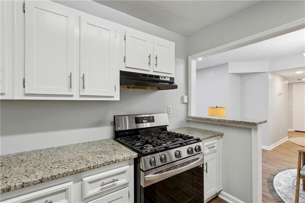 1308 Natchez Trace Atlanta, GA 30350 - Photo 15 of 27 a kitchen with granite countertop white cabinets and appliances