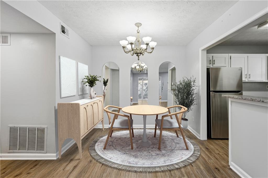 1308 Natchez Trace Atlanta, GA 30350 - Photo 10 of 27 a dining room with wooden floor a chandelier a wooden table and chairs