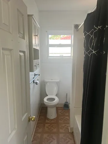 a bathroom with a toilet and a shower