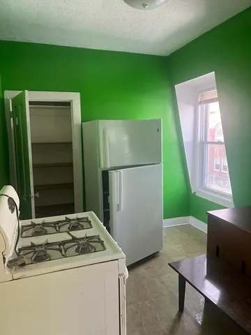 a kitchen with a refrigerator and a stove