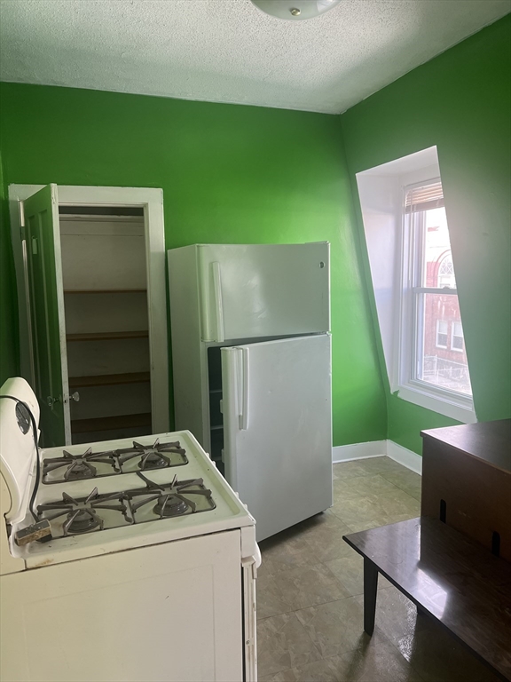 1241 North High Street, Unit 2 Fall River, MA 02720 - Photo 6 of 12 a kitchen with a refrigerator and a stove