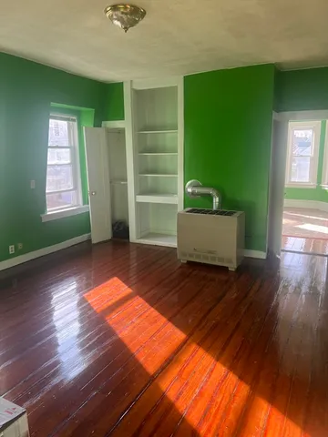 a view of empty room with stairs and wooden floor