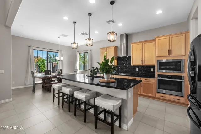 a kitchen with a dining table chairs refrigerator and microwave