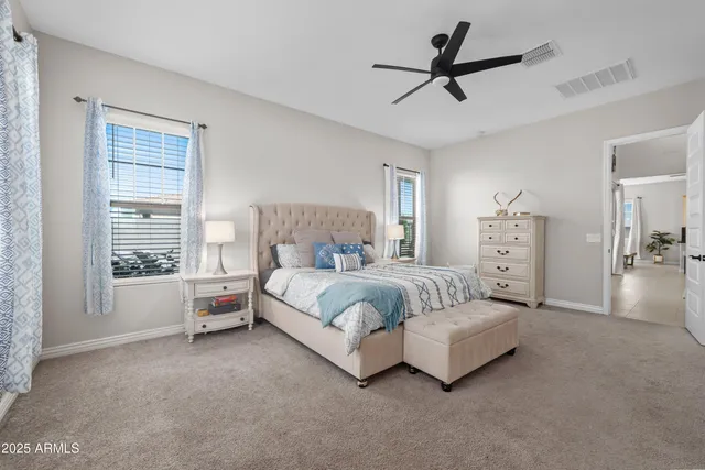 a spacious bedroom with a bed and a ceiling fan