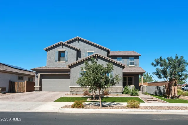 a kitchen with stainless steel appliances kitchen island granite countertop a stove a sink a refrigerator a counter with a dining table and chairs