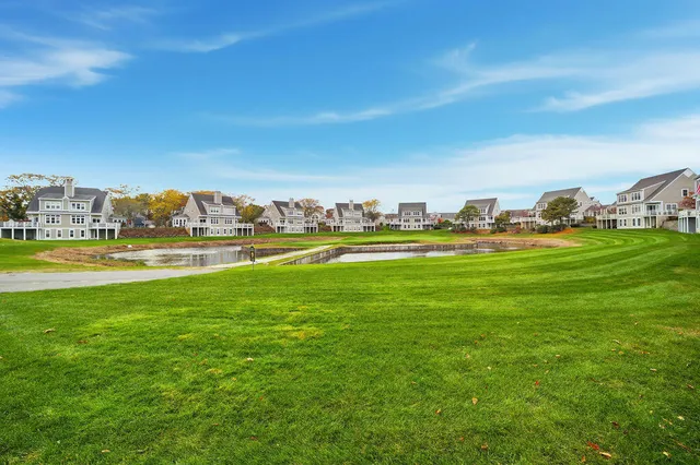 a view of yard with ocean and houses in the back