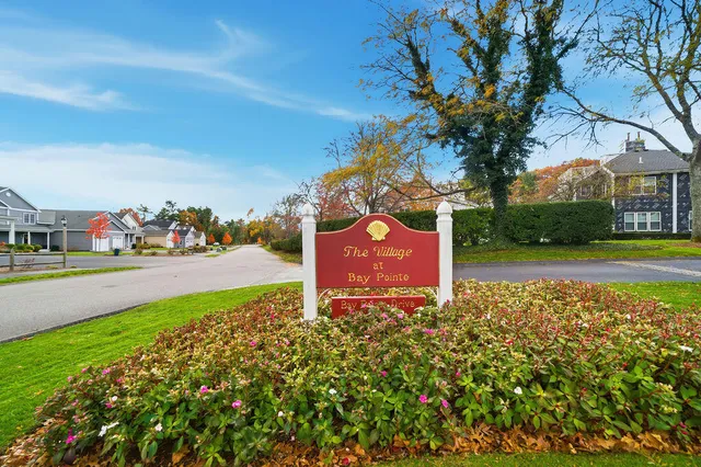a sign board with buildings in the background