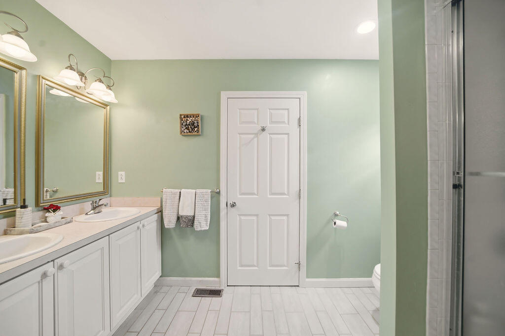 69 Bay Pointe Dr Extension, Unit 69 Buzzards Bay, MA 02532 - Photo 22 of 44 a bathroom with a double vanity sink and a mirror