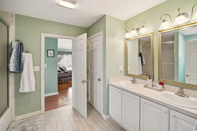 a bathroom with a double vanity sink shower and a mirror