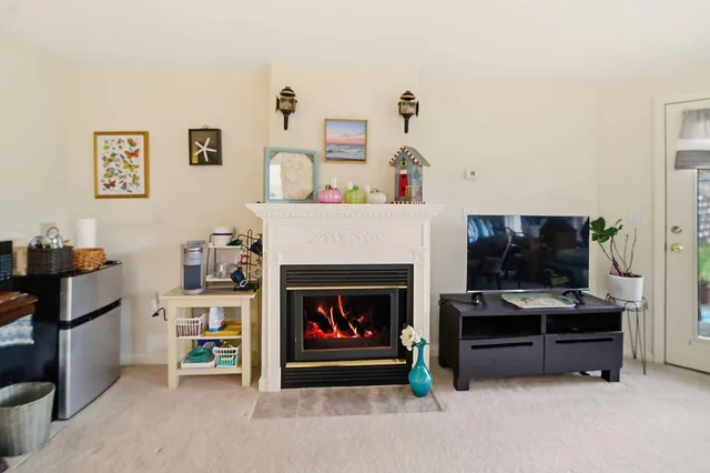 a living room with furniture a flat screen tv and a fireplace