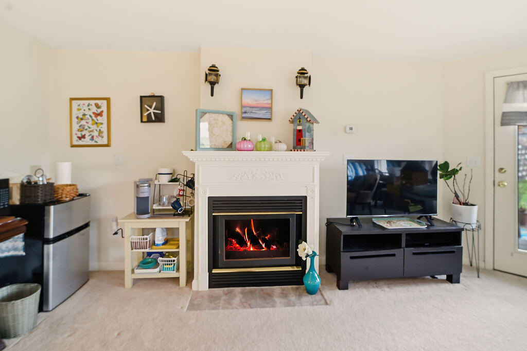 69 Bay Pointe Dr Extension, Unit 69 Buzzards Bay, MA 02532 - Photo 31 of 44 a living room with furniture a flat screen tv and a fireplace