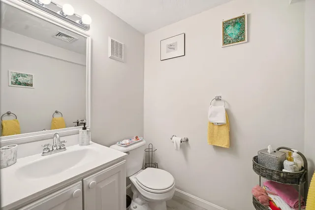 a bathroom with a toilet sink vanity and mirror