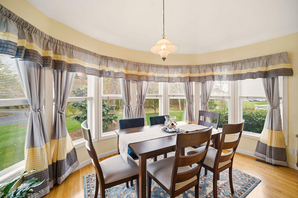 69 Bay Pointe Dr Extension, Unit 69 Buzzards Bay, MA 02532 - Photo 6 of 44 a view of a dining room with furniture large windows and wooden floor