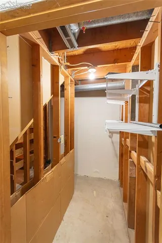 a view of walk in closet with empty racks