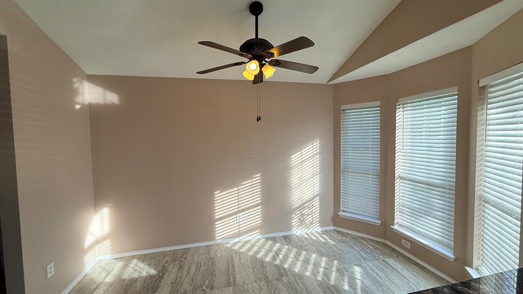 12259 Rim Rock Road Dallas, TX 75253 - Photo 4 of 17 Unfurnished room with lofted ceiling and ceiling fan