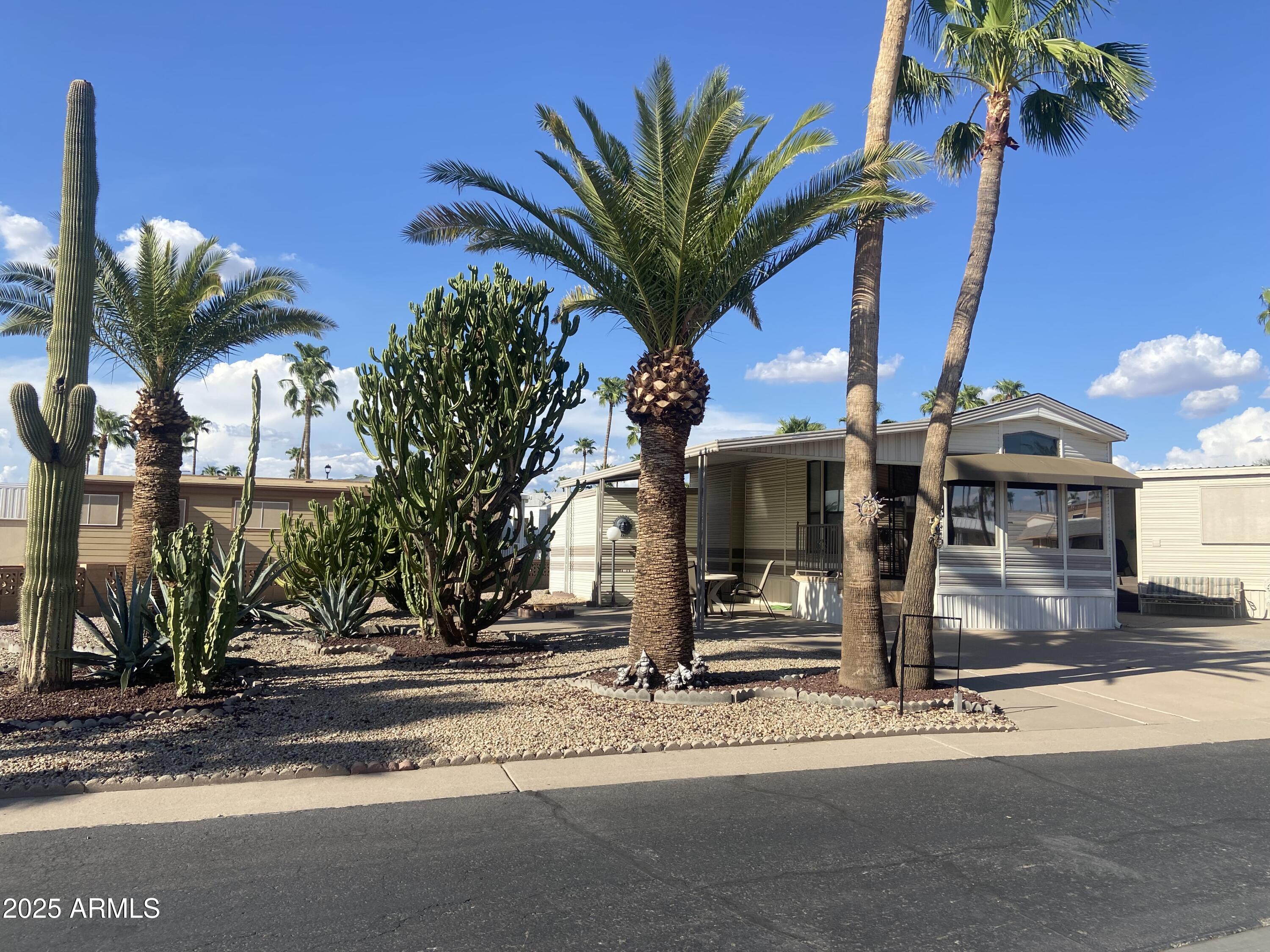 a view of a house with a yard and palm trees