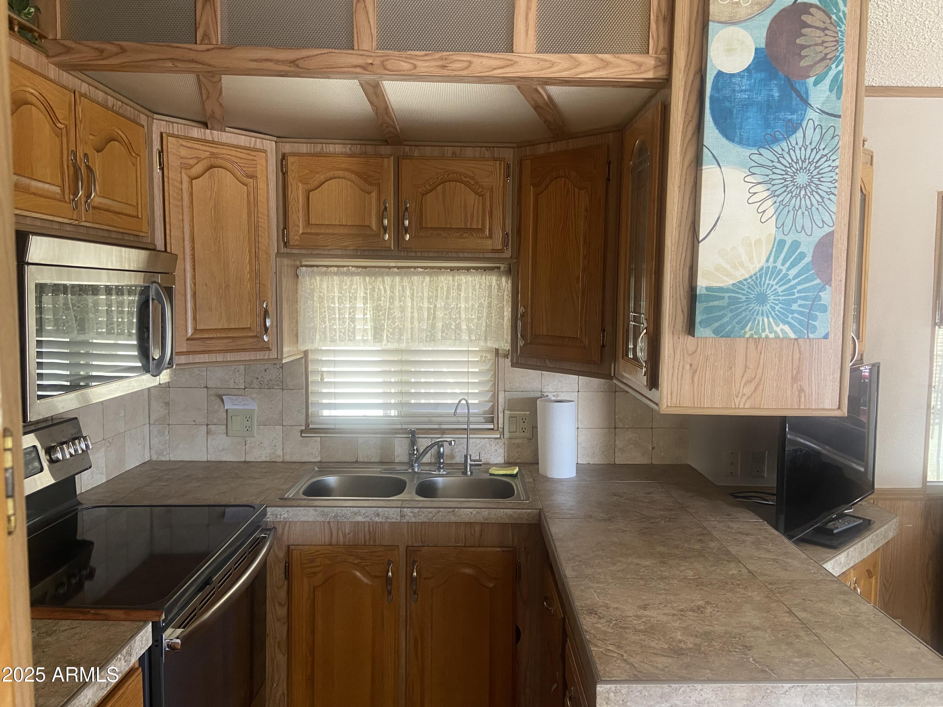 1206 West Klamath Avenue Apache Junction, AZ 85119 - Photo 14 of 35 a kitchen with granite countertop a stove and a sink