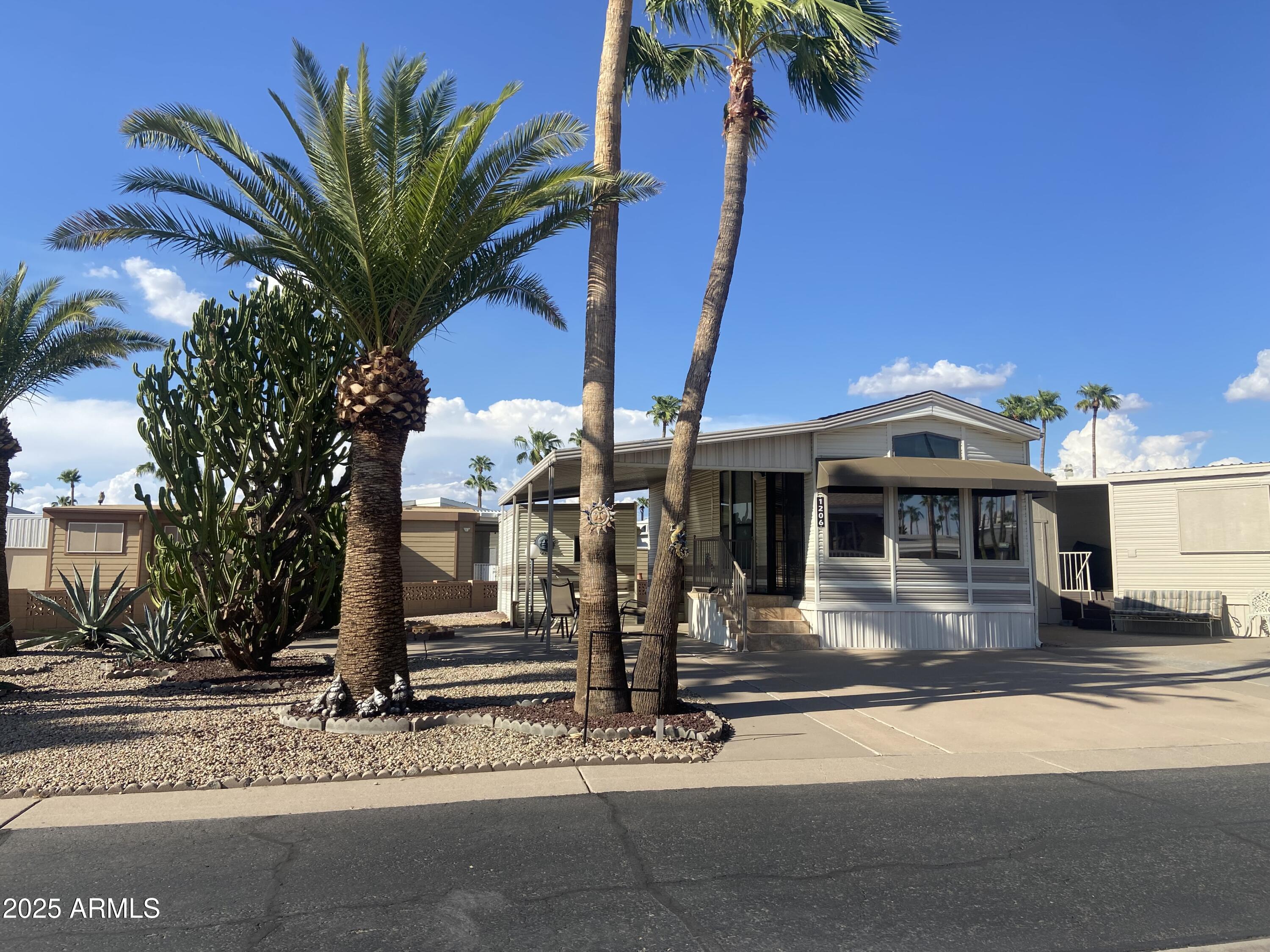 1206 West Klamath Avenue Apache Junction, AZ 85119 - Photo 2 of 35 a front view of a house with garden