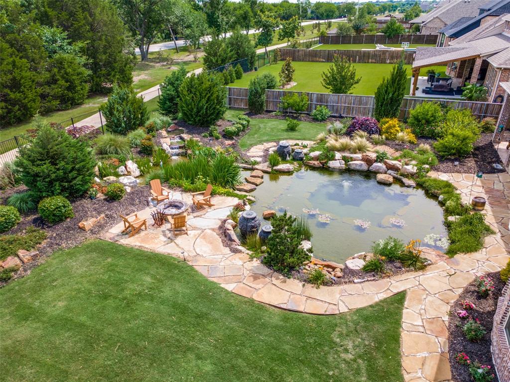 388 Bethany Road Sunnyvale, TX 75182 - Photo 39 of 40 Expansive backyard featuring a natural swimming pond with water features, mature landscaping, and a manicured lawn