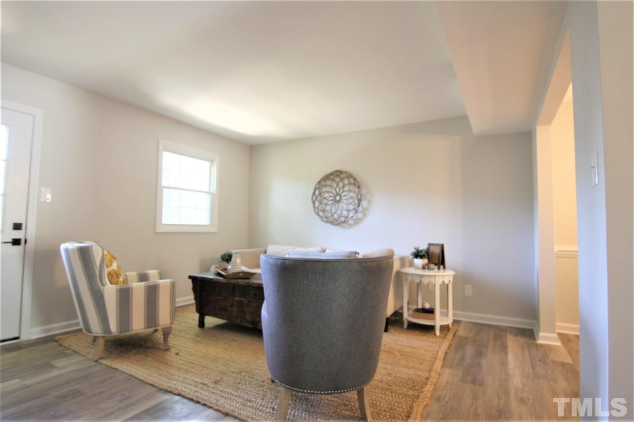 6367 New Market Way, Unit 6367 Raleigh, NC 27615 - Photo 8 of 20 a living room with a table and a chair