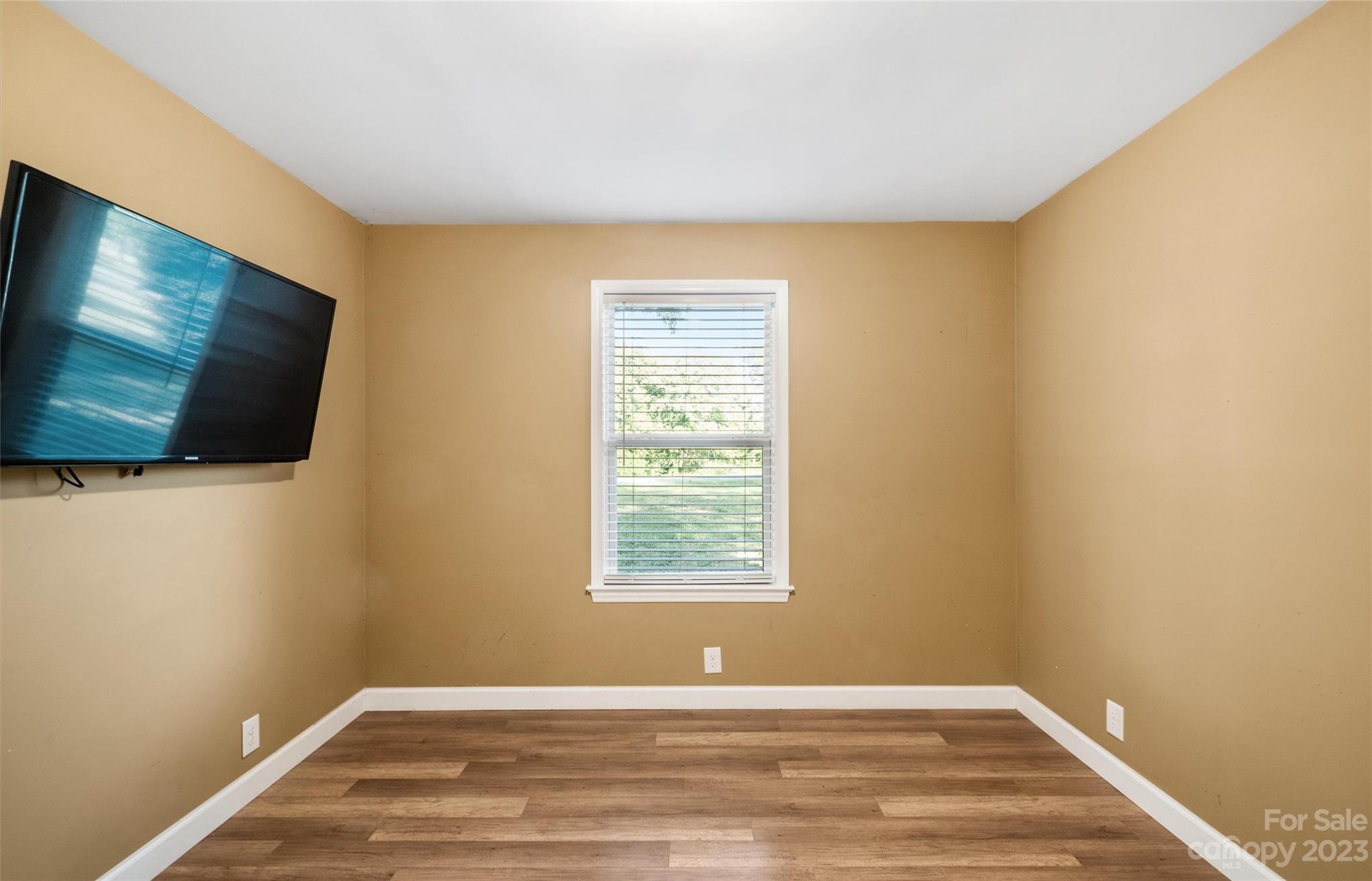 915 Harper Road Gastonia, NC 28056 - Photo 15 of 27 a view of an empty room with wooden floor and a flat screen tv