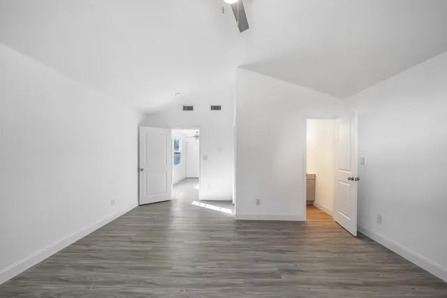a view of a room with wooden floor and white walls