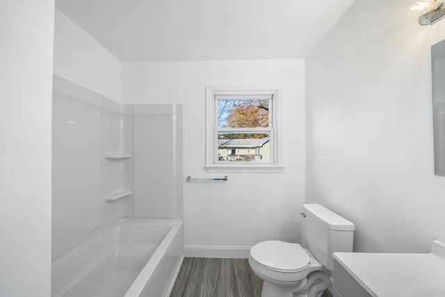 a white toilet sitting next to a bath tub